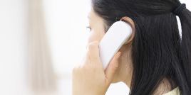 電話で問い合わせしている女性