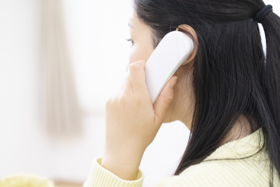 電話で問い合わせをする女性